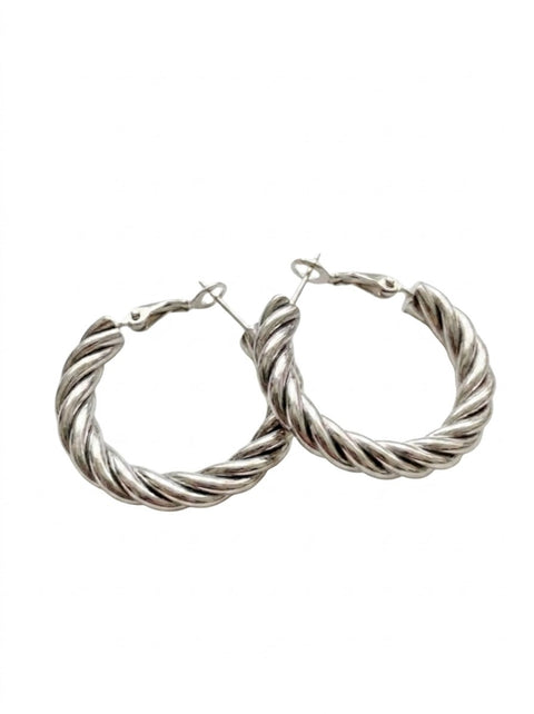 A pair of large silver-toned twisted hoop earrings with a textured rope-like finish and secure clasp backs, shown on a plain white background.