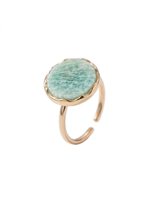 A gold-toned open-shank ring featuring a round, textured light green stone bezel-set on a plain white background.