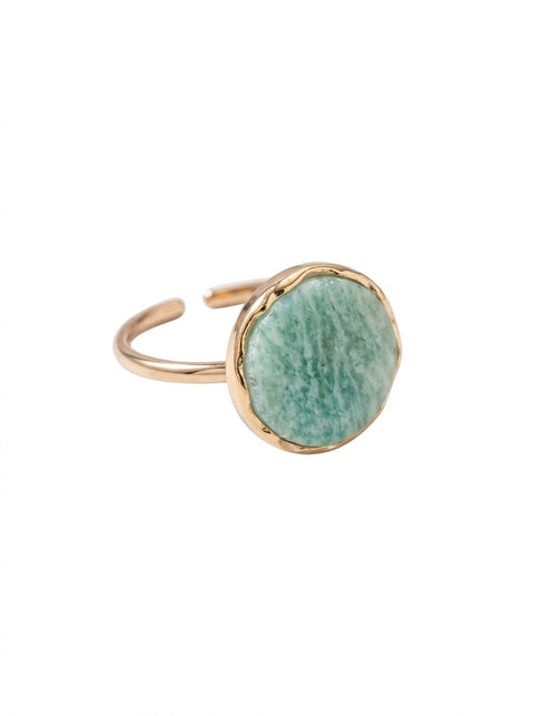A gold-plated adjustable ring featuring a round, organic-shaped green stone bezel-set on a plain white background.