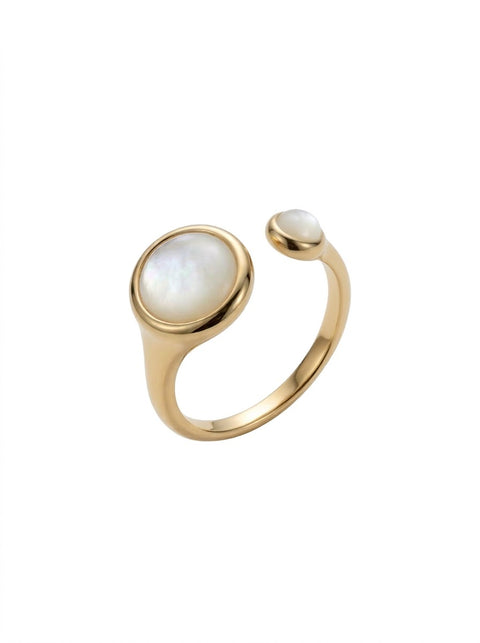 A gold open ring featuring a large oval white mother-of-pearl cabochon and a smaller matching oval stone on the band, set against a plain white background.