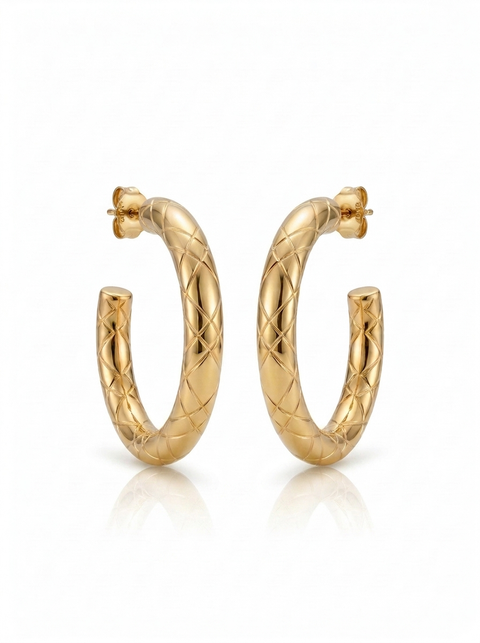 A pair of gold hoop earrings with a textured, diamond-patterned woven design, displayed on a clean white background with a soft reflection below.